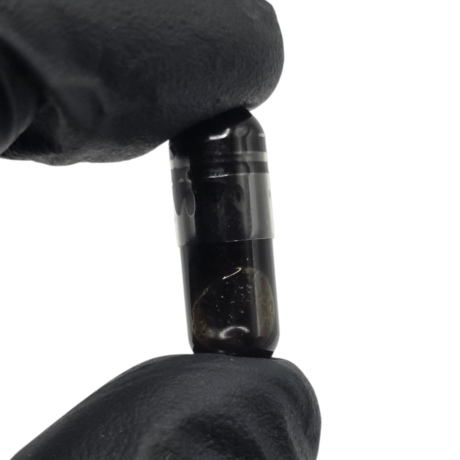 Black cylindrical object held by a gloved hand on a white background