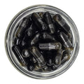Clear jar filled with black and transparent bullet-shaped objects on a white background