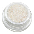 Small clear container filled with white granular substance on a white background
