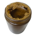 Jar of brown paste with a white background